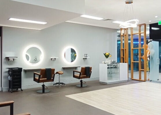 Modern interior of Cuts By Carella, Cairns City, Queensland, AU—well-lit salon with stylish chairs and mirrors.