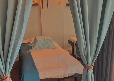 Relaxing spa room at Deep Tissue Therapies, Bondi, New South Wales, AU with a massage bed and curtains.
