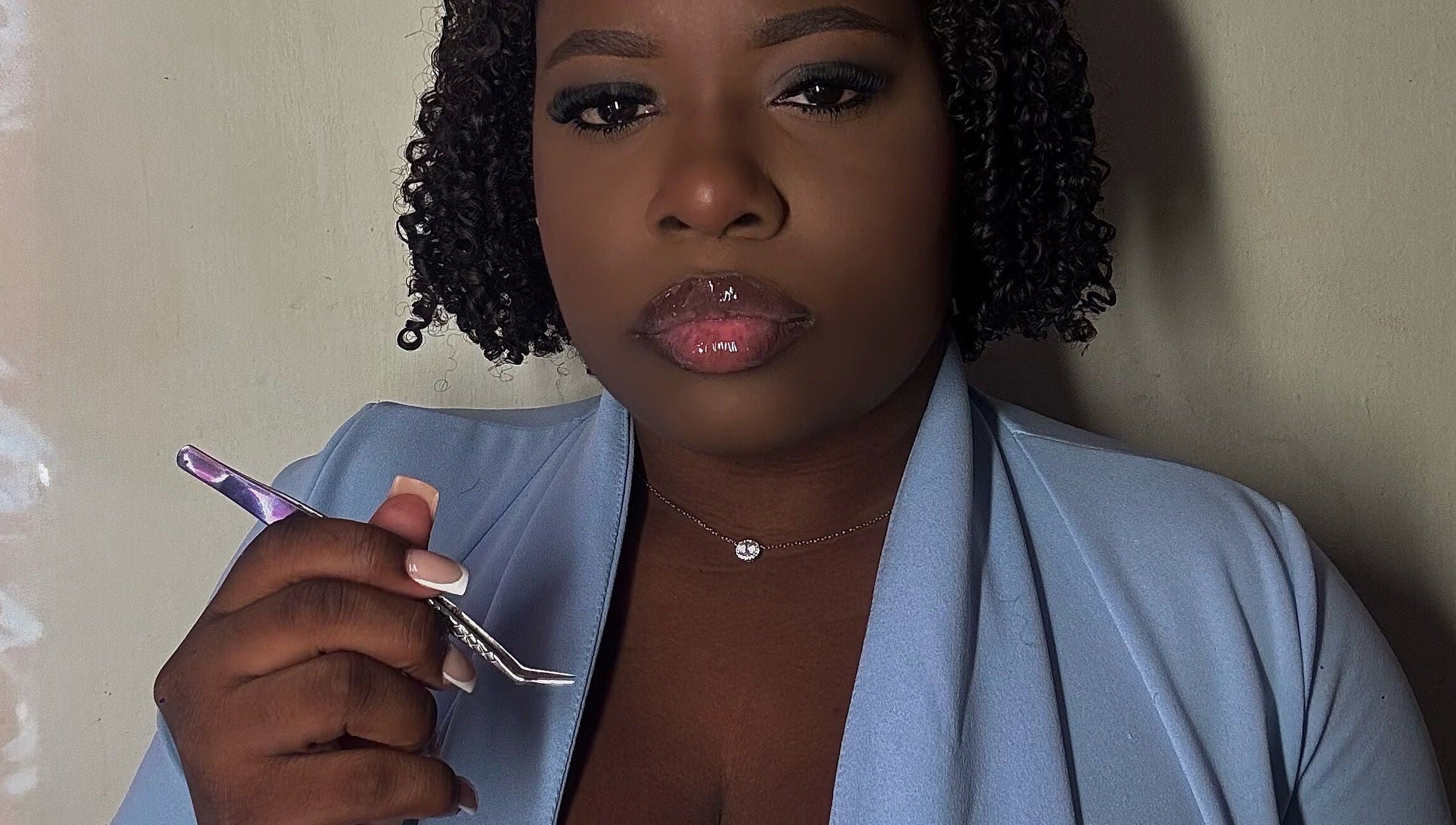 Expert lash artist at Glamorous Lashes and More, Willemstad, Curaçao, CW, holding a precision tool.