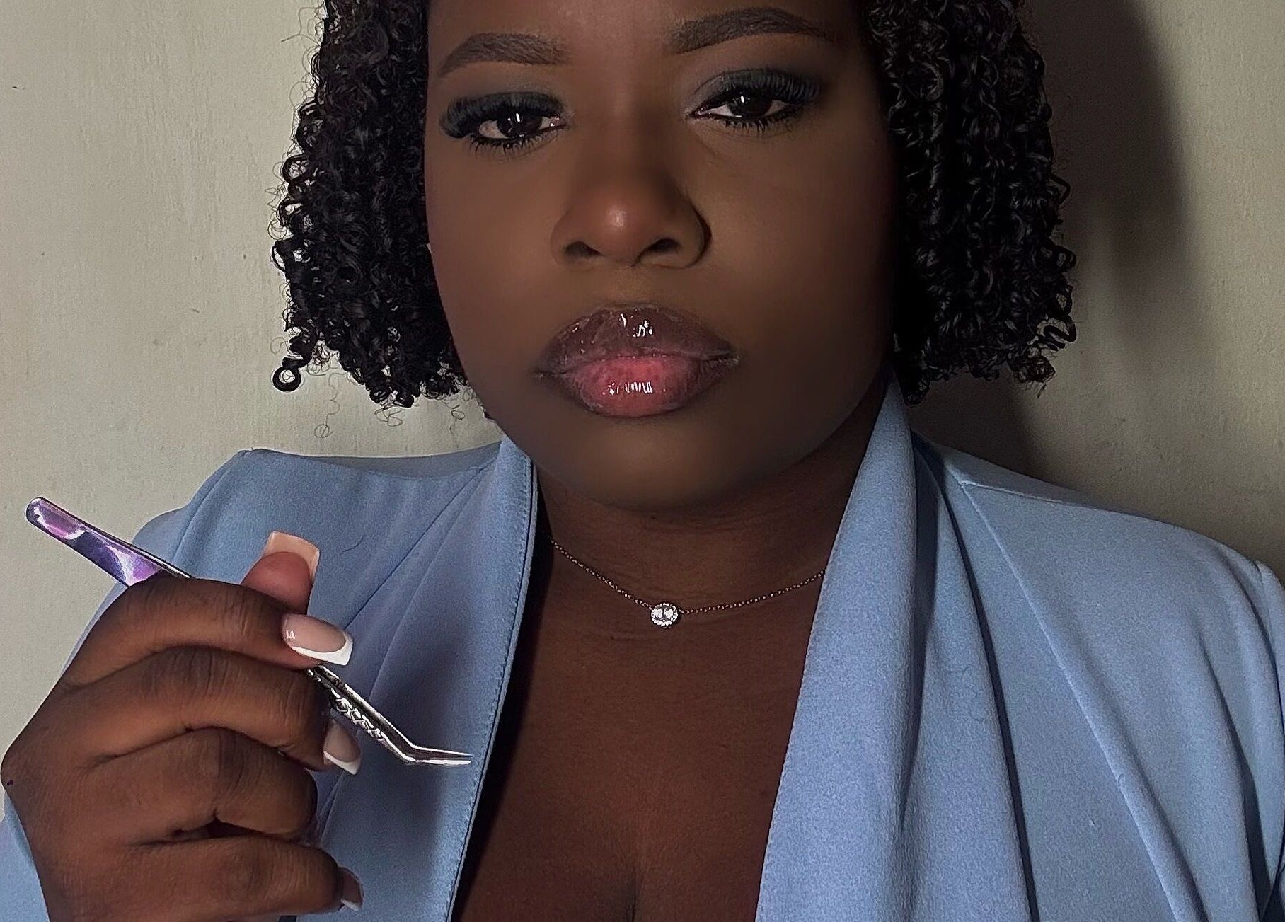 Expert lash artist at Glamorous Lashes and More, Willemstad, Curaçao, CW, holding a precision tool.