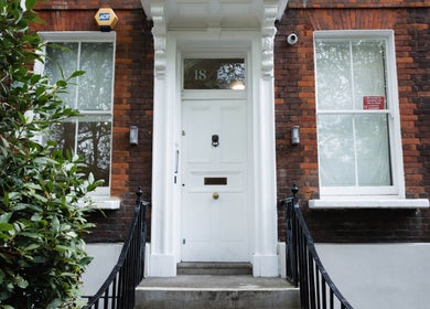 Classic brick facade of Nayii Atelier奈野 at London, England, GB. Welcoming white door with greenery.