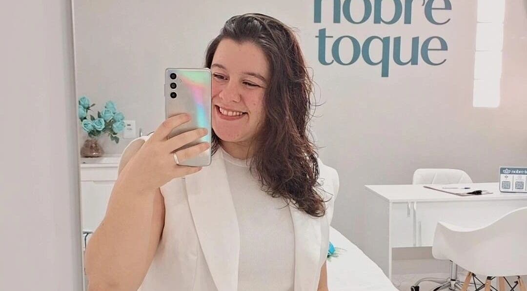 Cliente sorridente tirando selfie no Nobre Toque, São Paulo, São Paulo, BR.