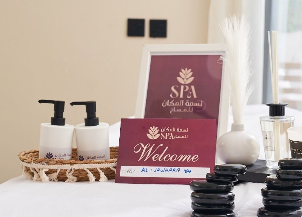 Elegant spa setup at نسمة المكان للسيدات خدمة منزلية in Riyadh, Riyadh Province, SA featuring candles and oils.