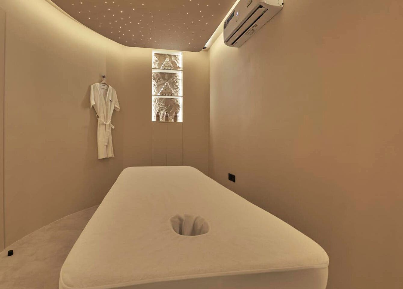 Relaxing massage room at Via Sand Spa | Men, Riyadh, Saudi Arabia, with ambient lighting and plush bed.
