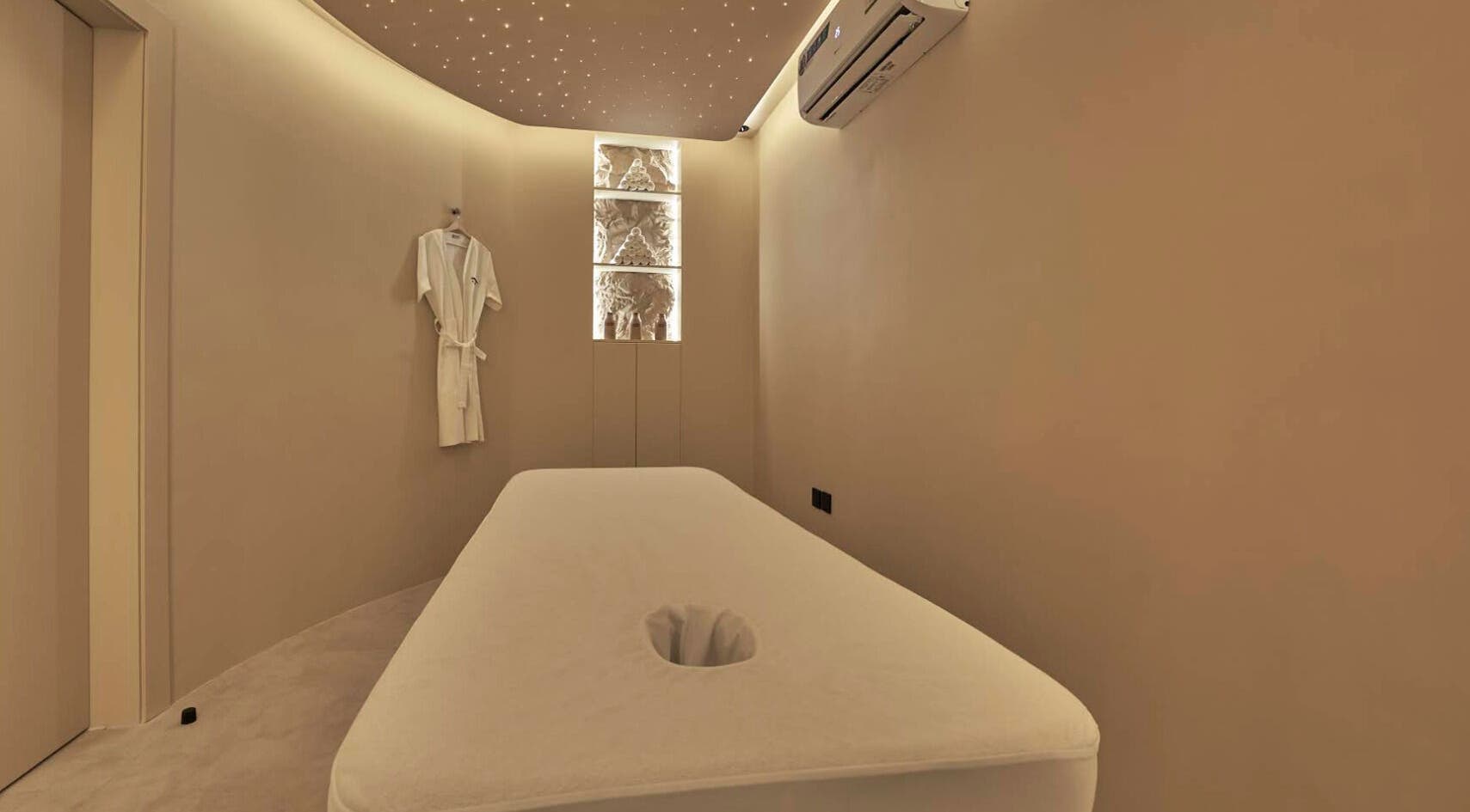 Relaxing massage room at Via Sand Spa | Men, Riyadh, Saudi Arabia, with ambient lighting and plush bed.