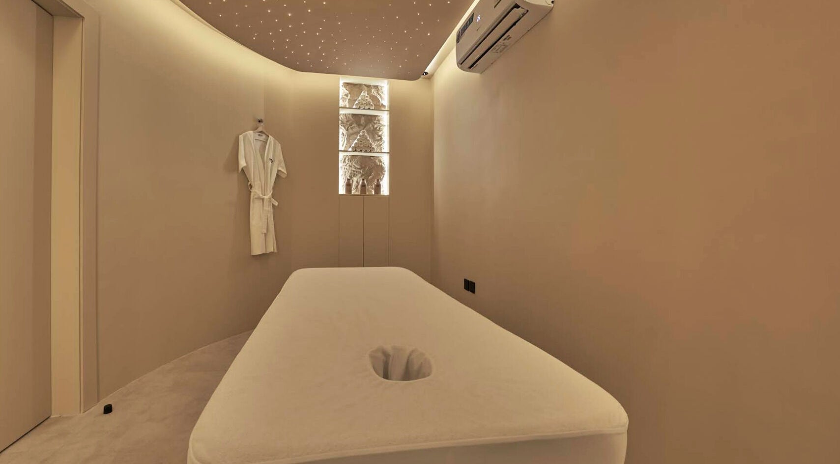 Relaxing massage room at Via Sand Spa | Men, Riyadh, Saudi Arabia, with ambient lighting and plush bed.
