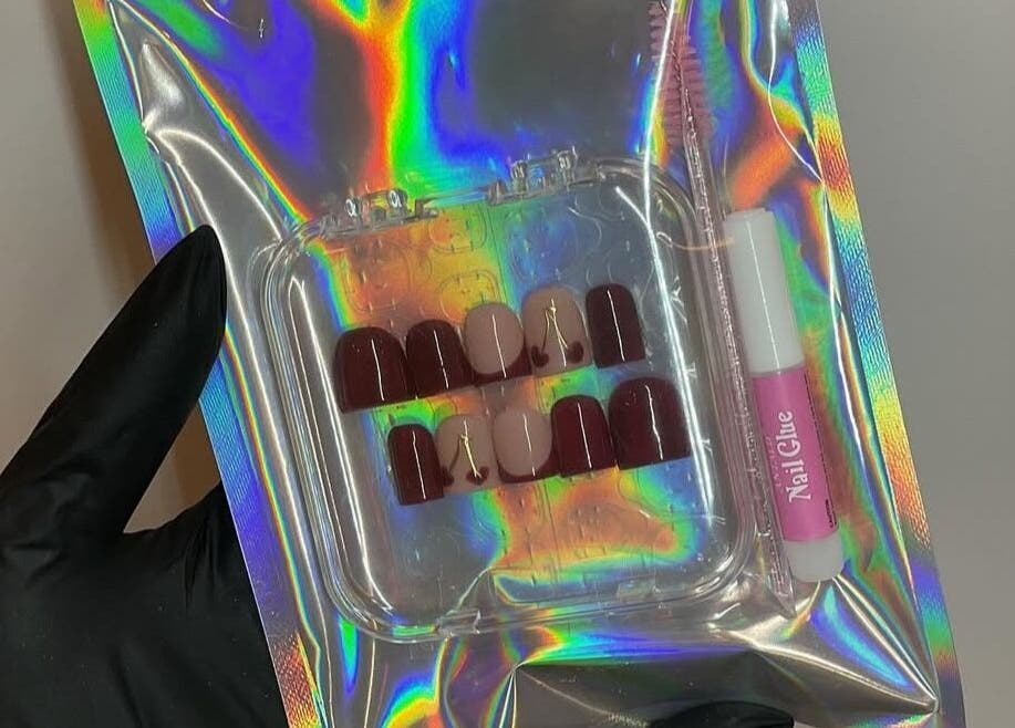 HC BEAUTY nail set in holographic packaging, Rossendale, England, GB, featuring deep red and nude nails.