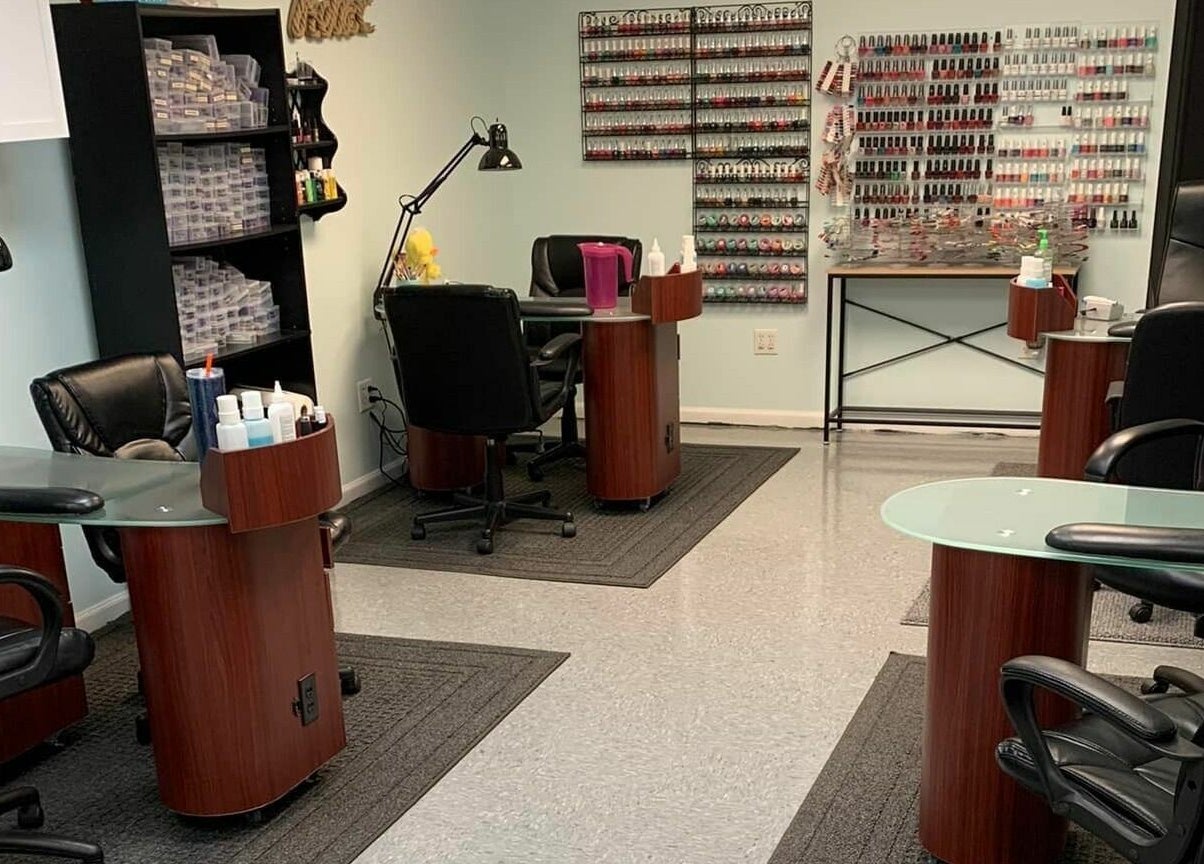 Modern nail station at Hair'N Dip-ity, Littlestown, Pennsylvania, US, featuring sleek chairs and polished desks.