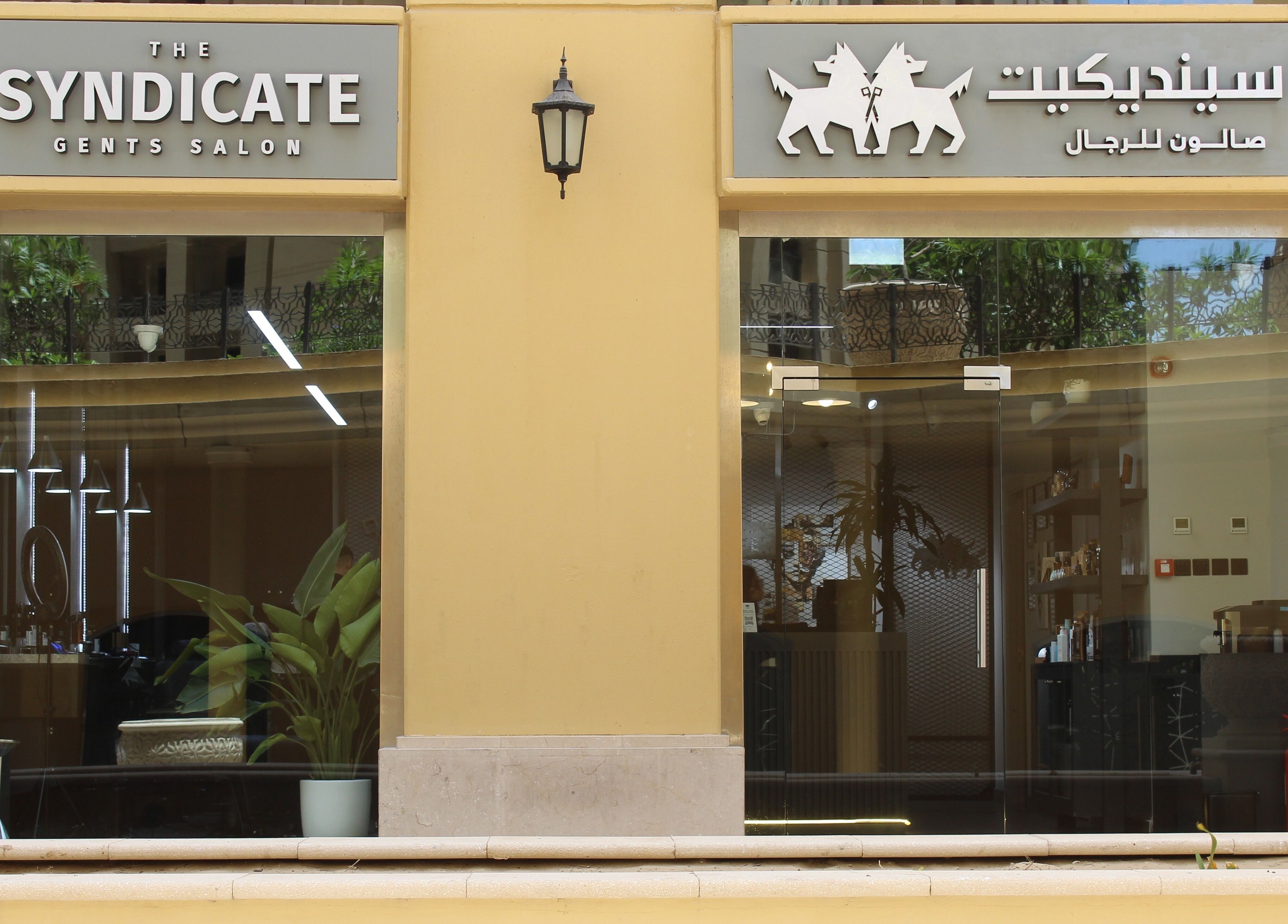 Exterior of The Syndicate Gents Salon in Dubai, AE showcasing modern signage and inviting glass doors.