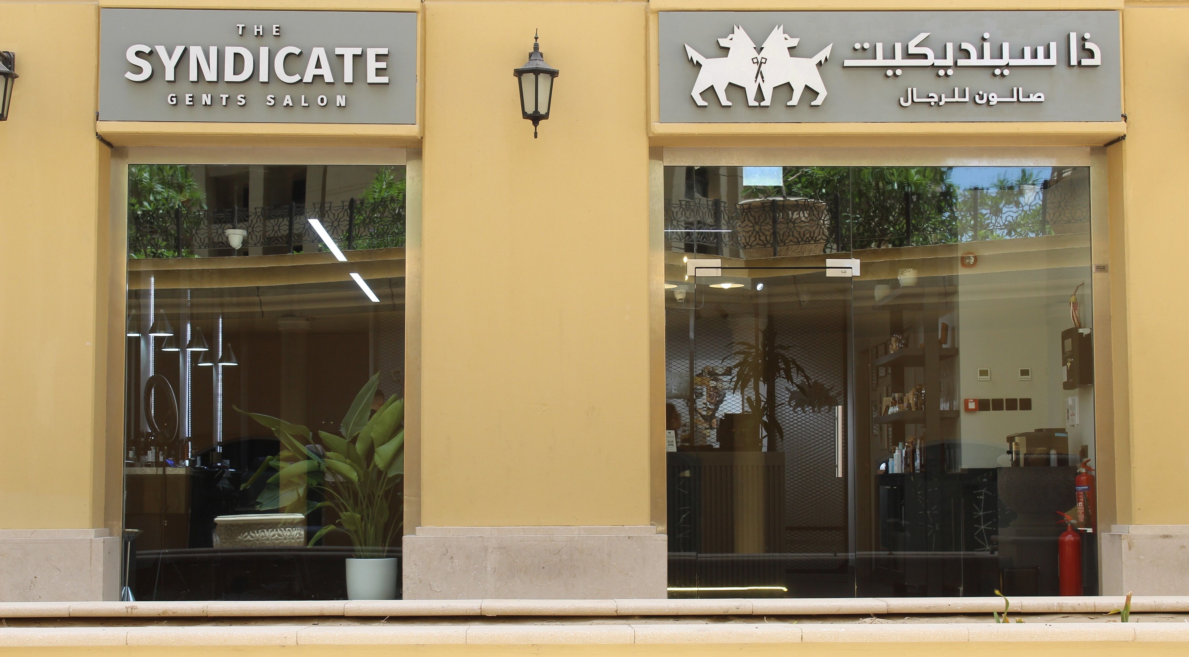 Exterior of The Syndicate Gents Salon in Dubai, AE showcasing modern signage and inviting glass doors.