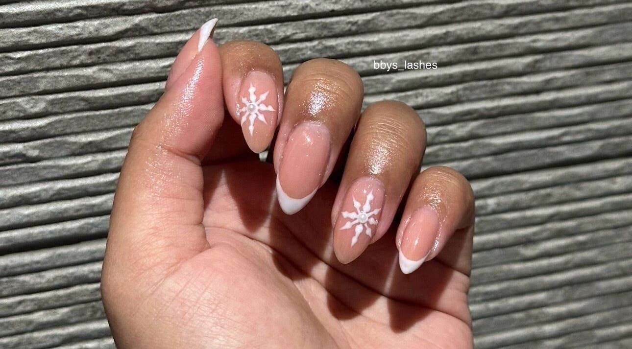 Close-up of elegant nail art with white designs at Bbys Lashes & Nails, Sheffield, England, GB.