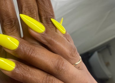 Bright yellow stiletto nails at Rasheedas Tips And Toes, Montego Bay, St. James, JM.