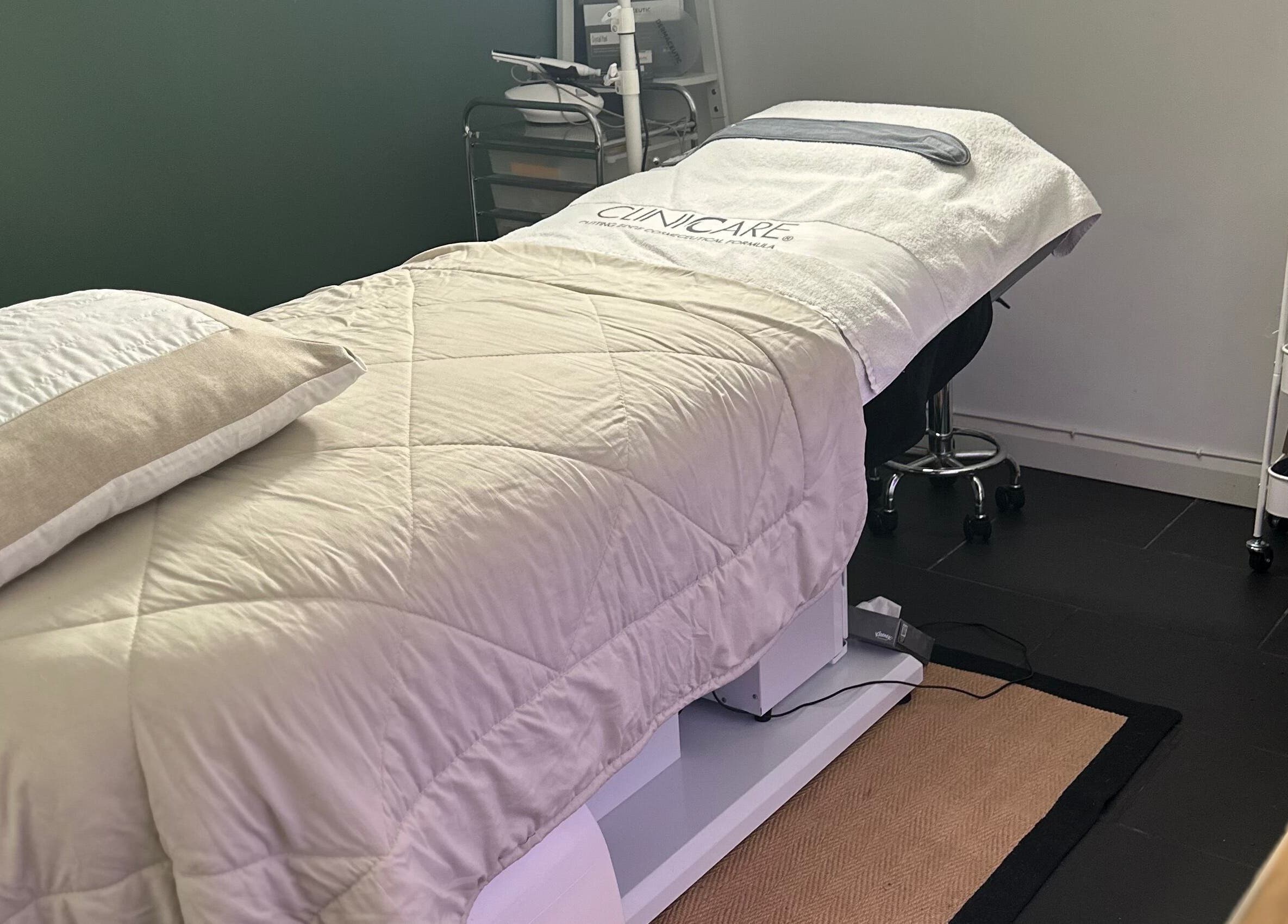 Cozy treatment room at The Renewed Lab, Harrold, England, GB, featuring a plush massage bed and skincare essentials.