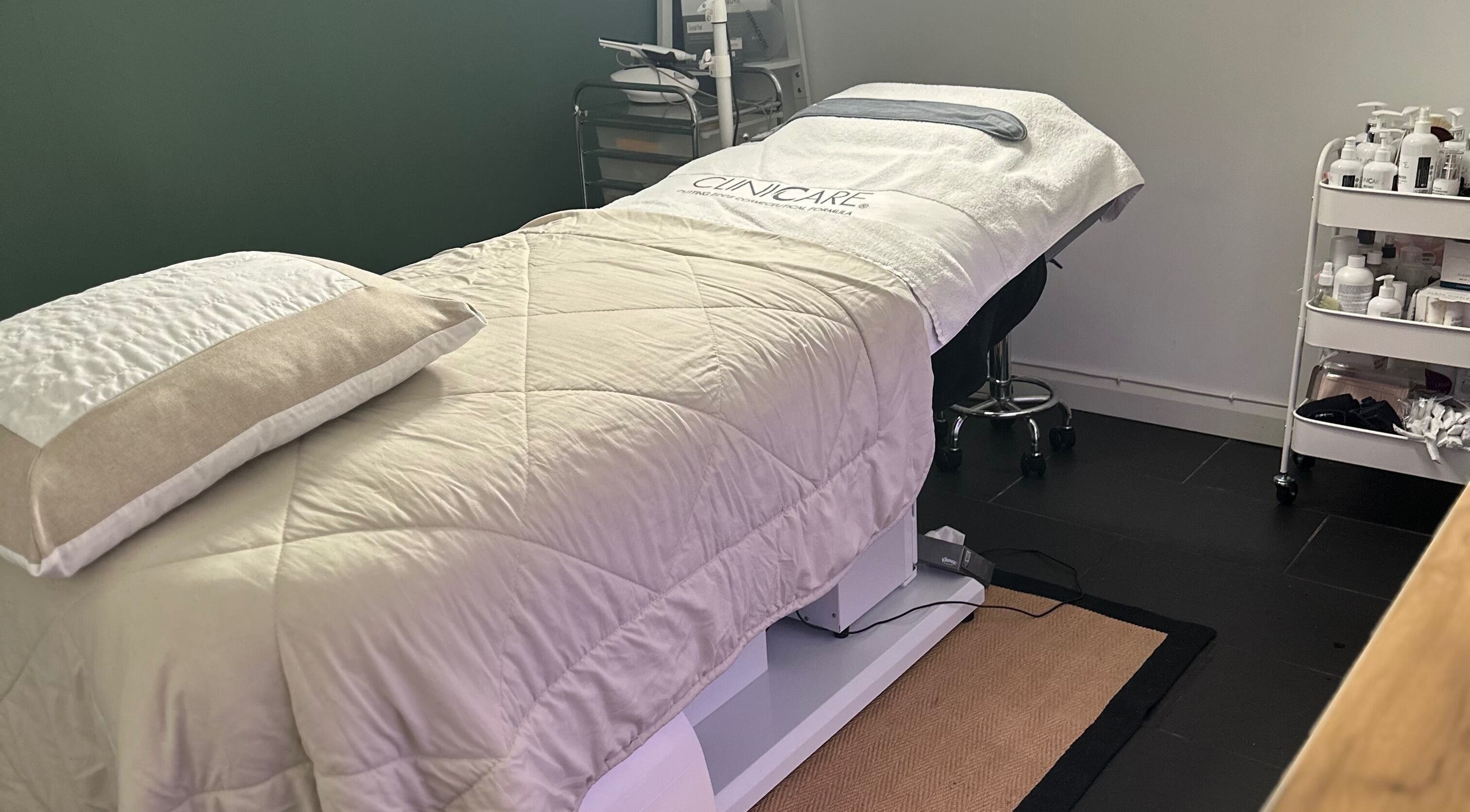 Cozy treatment room at The Renewed Lab, Harrold, England, GB, featuring a plush massage bed and skincare essentials.