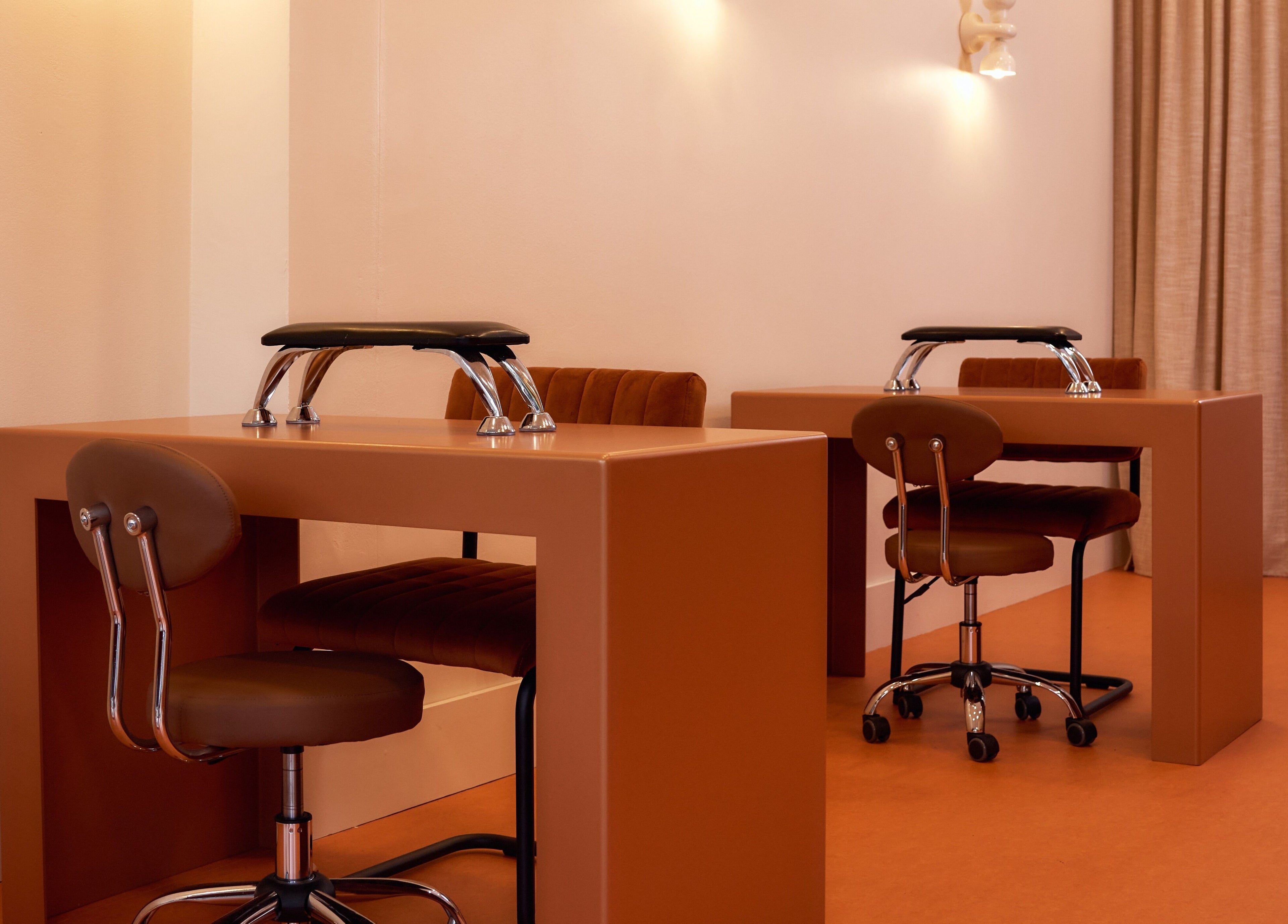 Modern nail stations at Painted in Darlinghurst, New South Wales, AU, with sleek chairs and warm lighting.