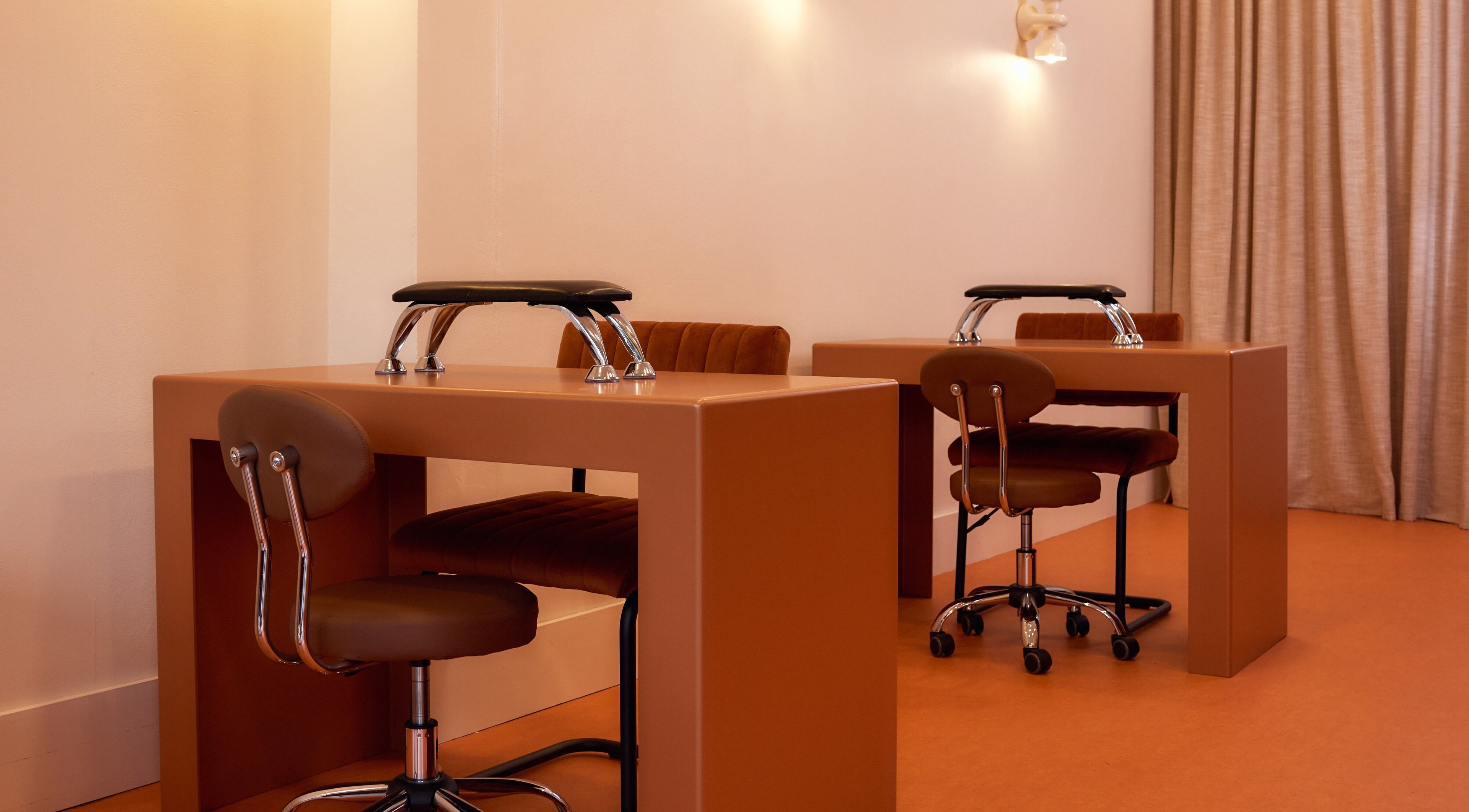 Modern nail stations at Painted in Darlinghurst, New South Wales, AU, with sleek chairs and warm lighting.