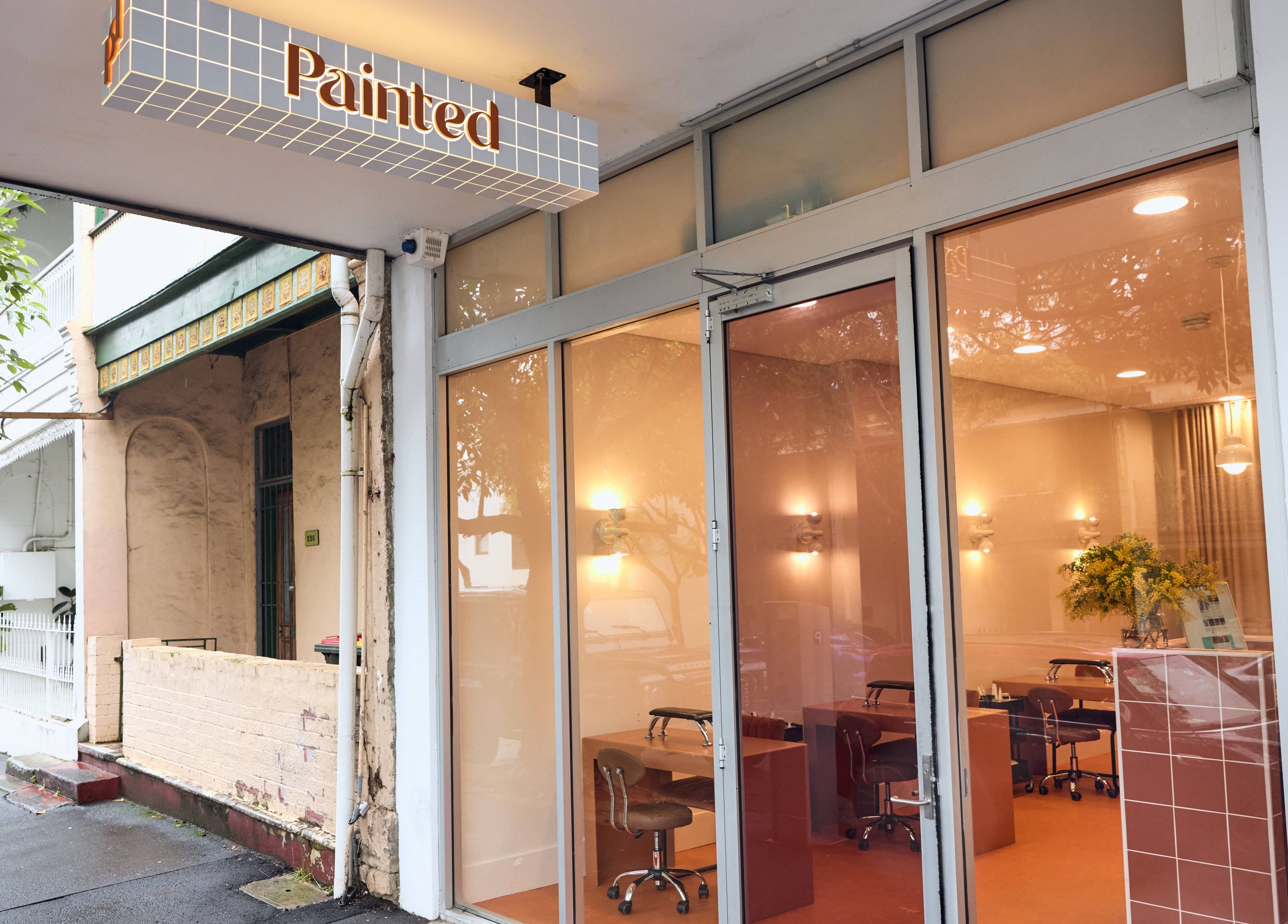 Exterior of Painted beauty salon in Darlinghurst, New South Wales, AU with stylish glass facade.