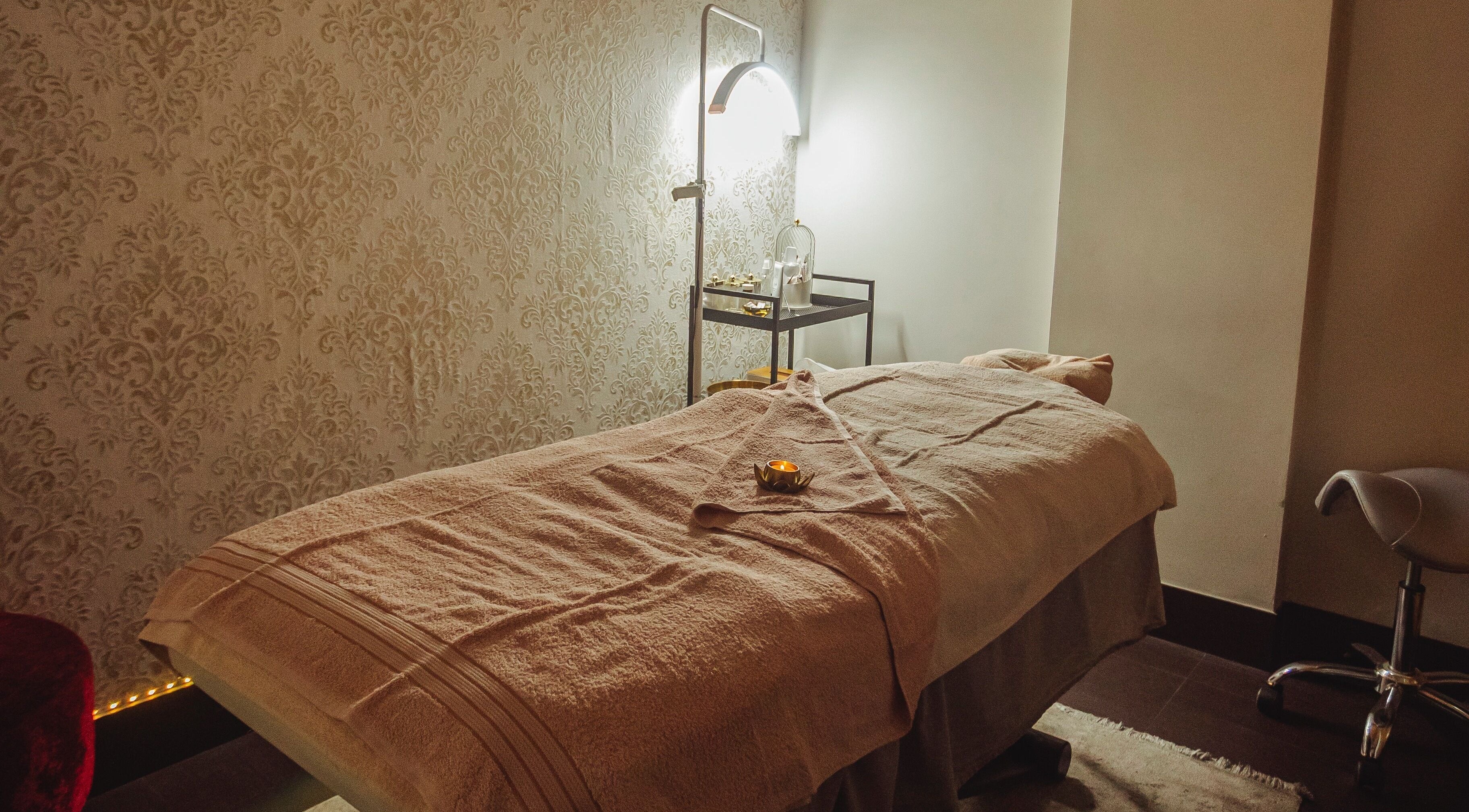 Sala de tratamento aconchegante na Cristiana Reis Beauty, Faro, Faro, PT, com maca e iluminação suave.
