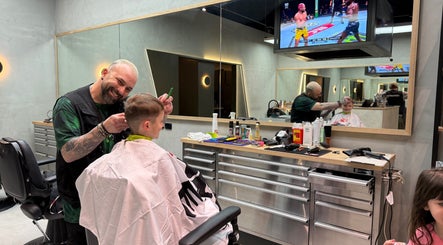 Admir the Barber giving a haircut to a child in Melbourne, Victoria, AU barber shop.