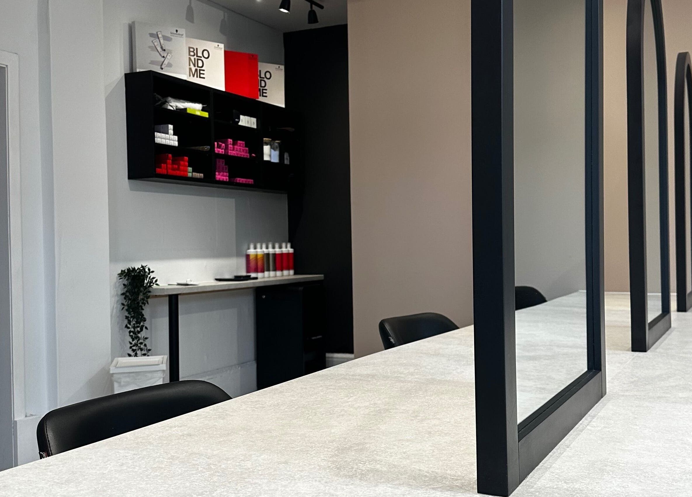 Modern salon setup at Exhibit Studio in Uphall, Scotland, GB, featuring stylish mirrors and seating.
