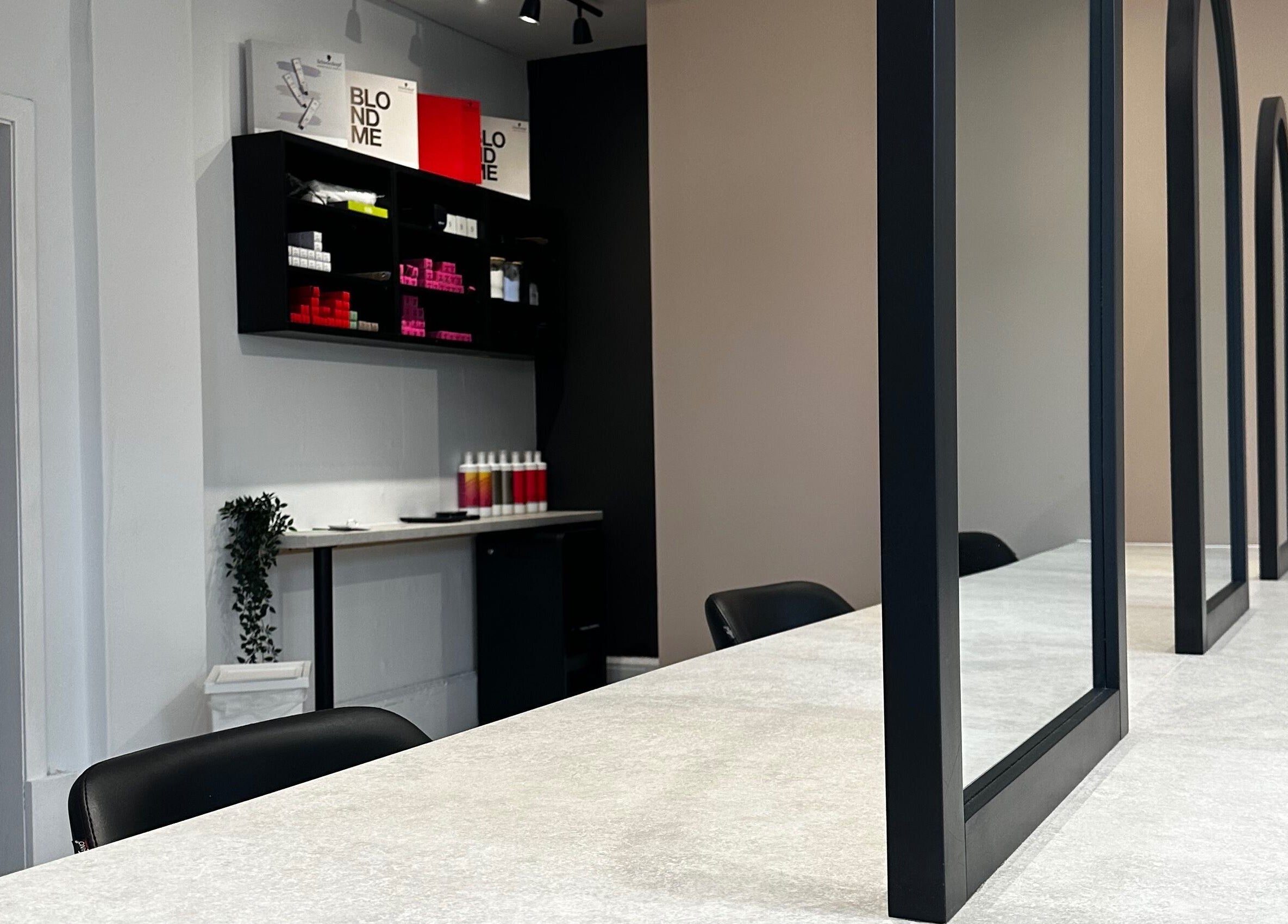 Modern salon setup at Exhibit Studio in Uphall, Scotland, GB, featuring stylish mirrors and seating.