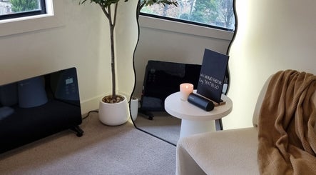 Relaxing space at Sleeping Beauty by Phoebe in Melbourne, Victoria, AU with a candle, mirror, and plant.