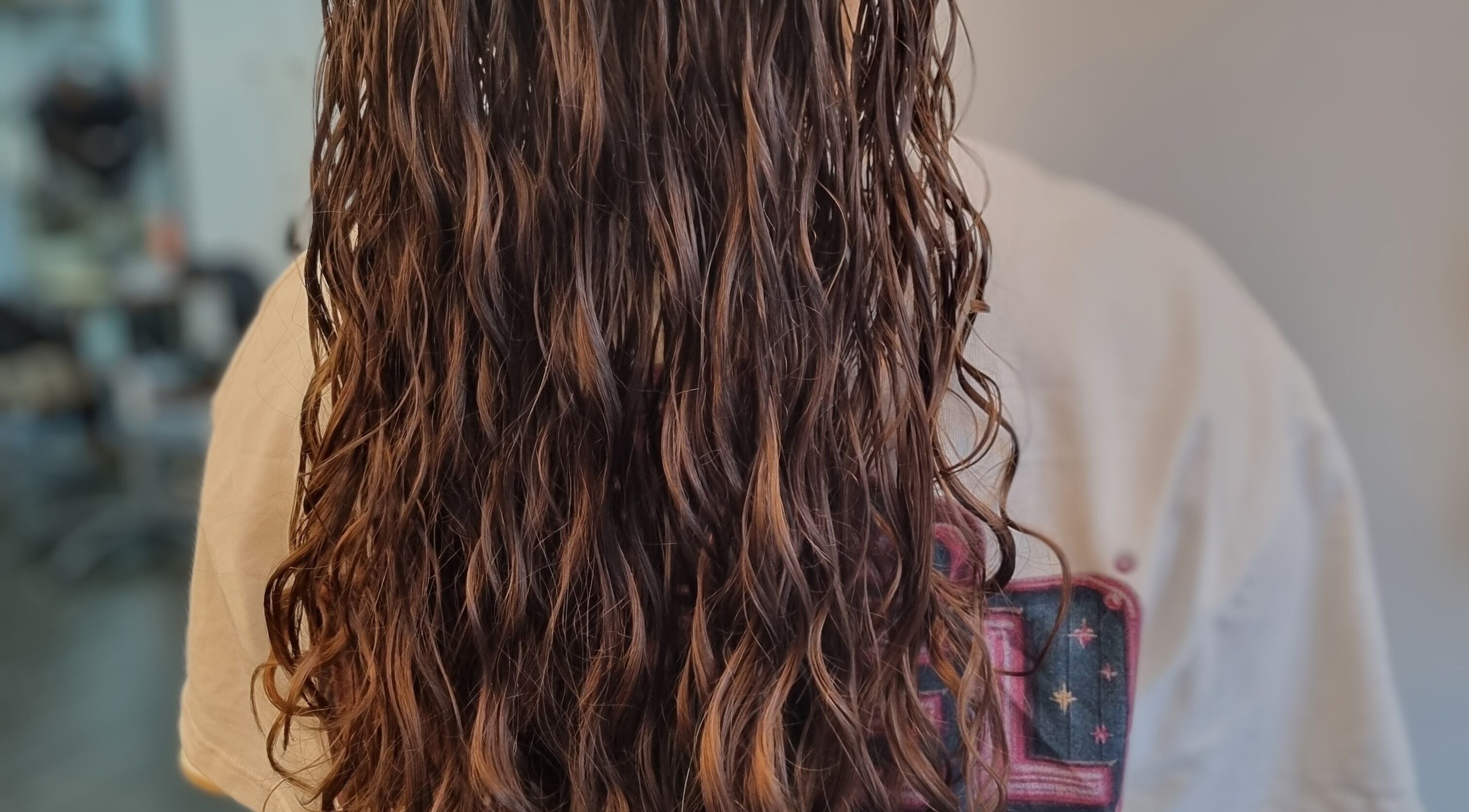 Close-up of flowing curly hair styled at Kay's Tresses, Birmingham, England, GB.