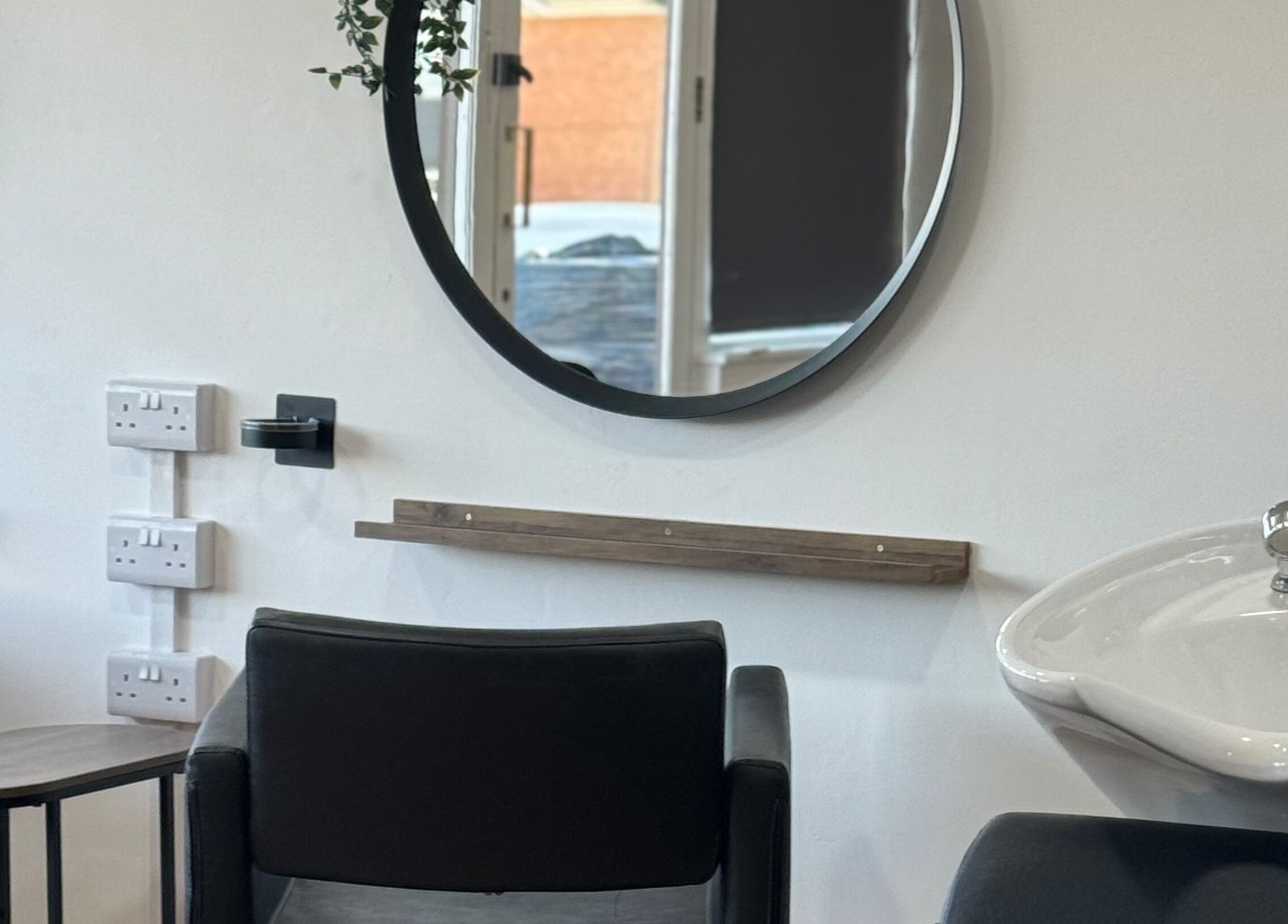 Stylish salon setup at Afterglow at 102, Fareham, England, GB, featuring a round mirror and chic styling chair.