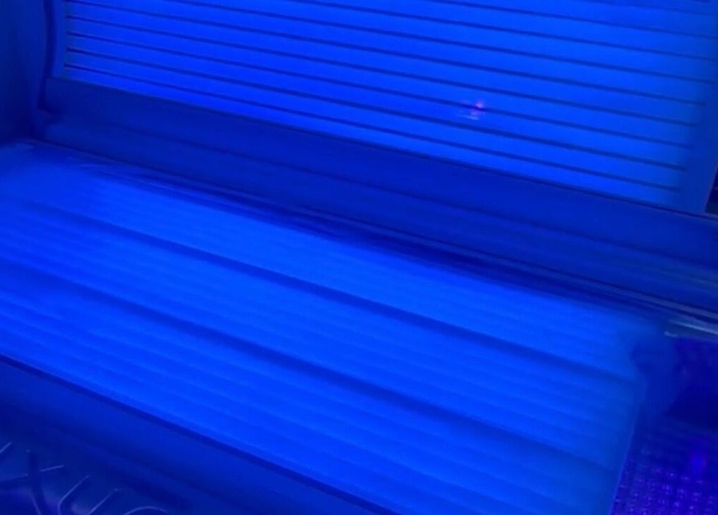 Tanning bed at Afterglow at 102, a beauty venue in Fareham, England, GB, showcasing its vibrant blue lights.