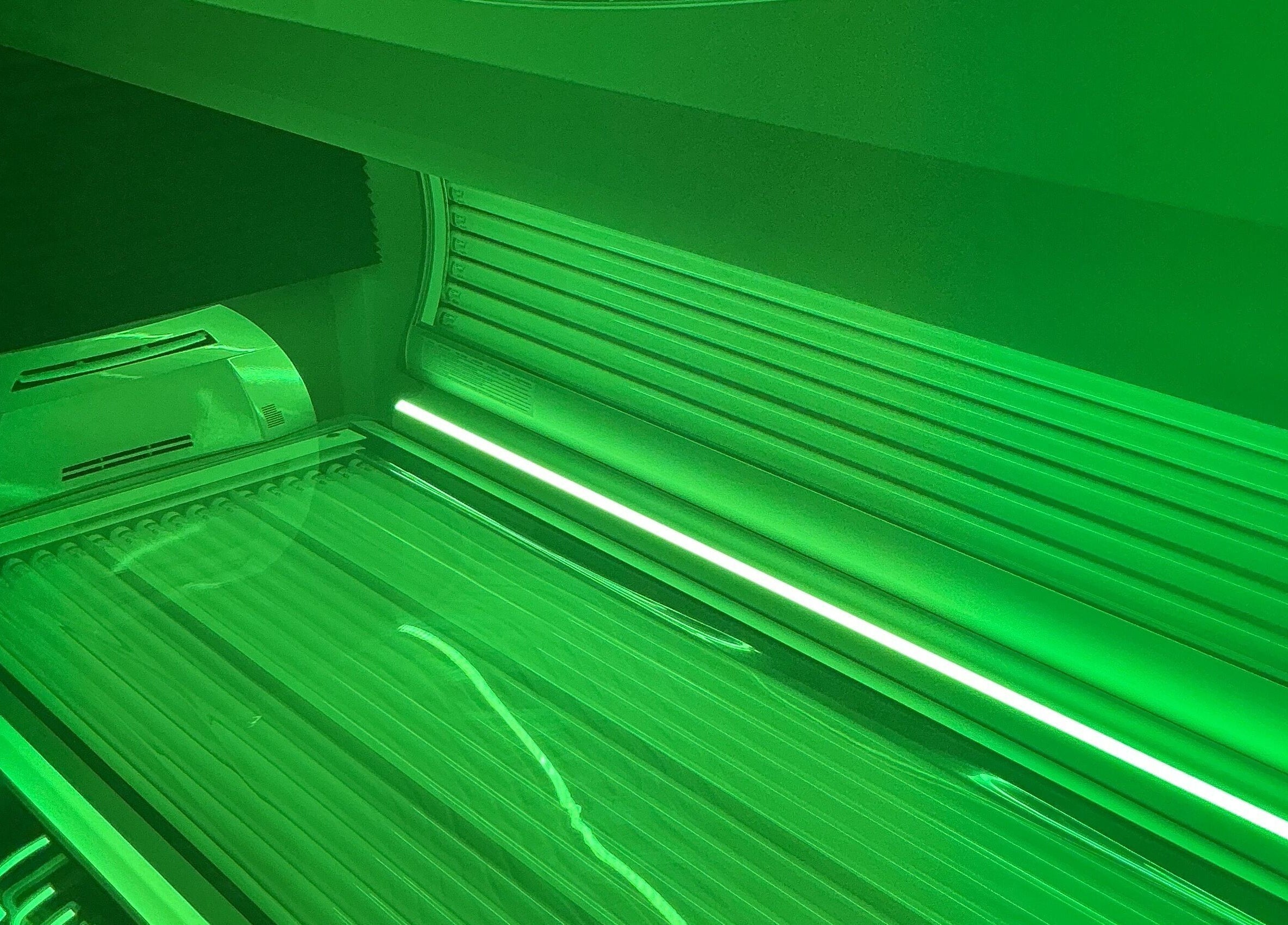 Neon-lit sunbed at Afterglow at 102, Fareham, England, GB, providing modern tanning experience.
