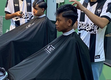 Barber styling hair at THE CUTZS in Machang, Kelantan, MY. Professional grooming in action.