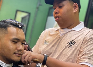 Barber giving a precise haircut at THE CUTZS, Machang, Kelantan, MY, showcasing skillful grooming.