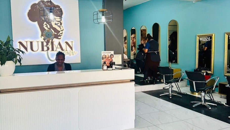 Reception and styling area at Nubian Crown Hyde Park, Sandton, Gauteng, ZA. Modern decor with mirrors and chairs.