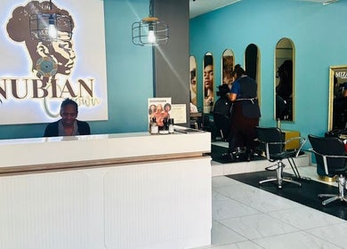 Reception and styling area at Nubian Crown Hyde Park, Sandton, Gauteng, ZA. Modern decor with mirrors and chairs.