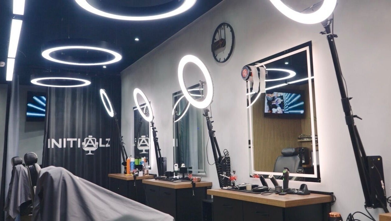 Sleek interior of Initialz Barbers in London, England, GB with modern lighting and barber chairs.