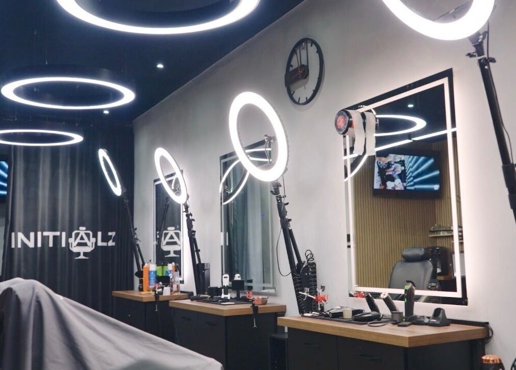 Sleek interior of Initialz Barbers in London, England, GB with modern lighting and barber chairs.