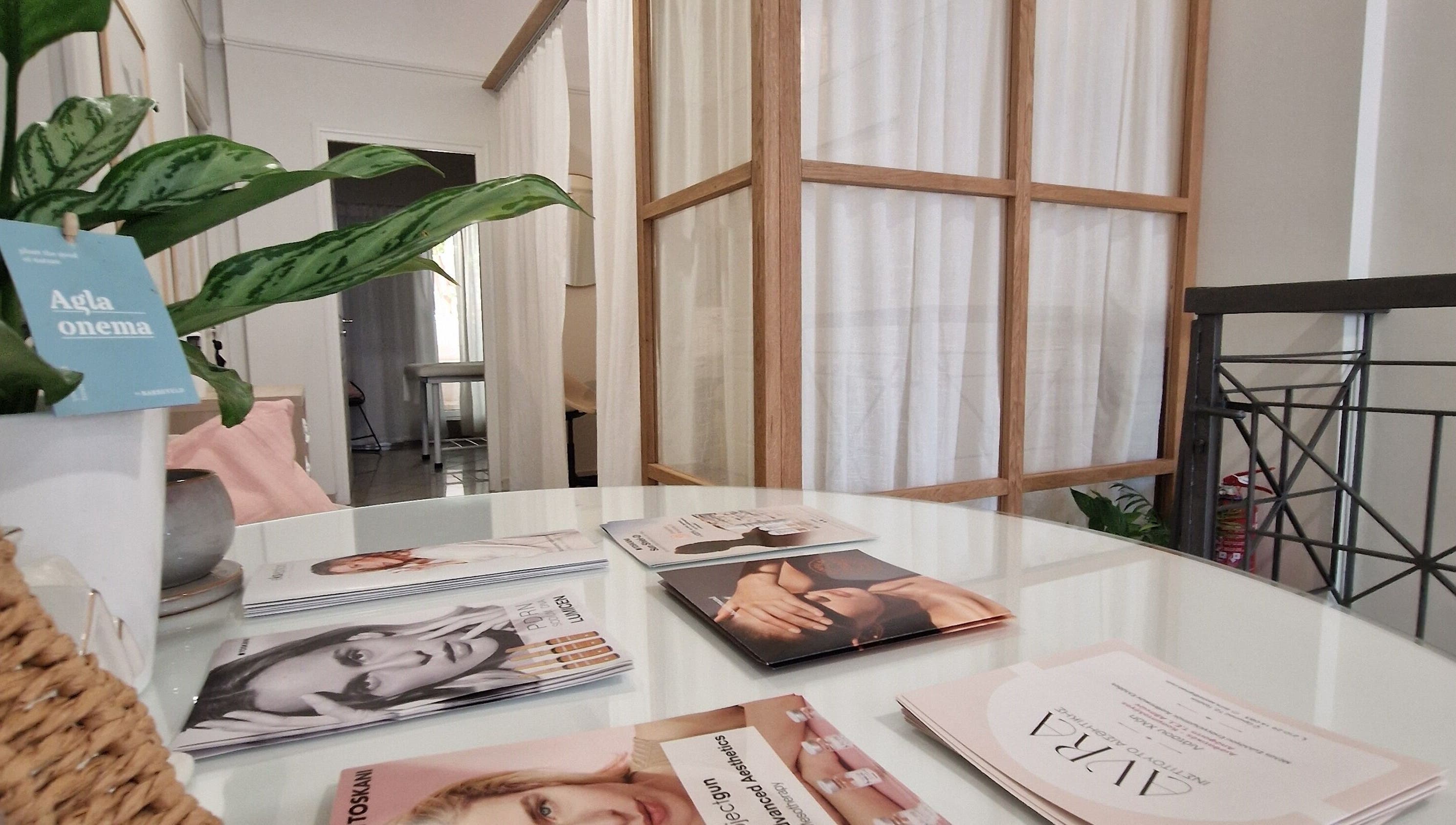 Καλαίσθητος χώρος υποδοχής στο Avra Ινστιτούτο Αισθητικής, Γαλάτσι, GR με φυτά και εμπνευστικά φυλλάδια.