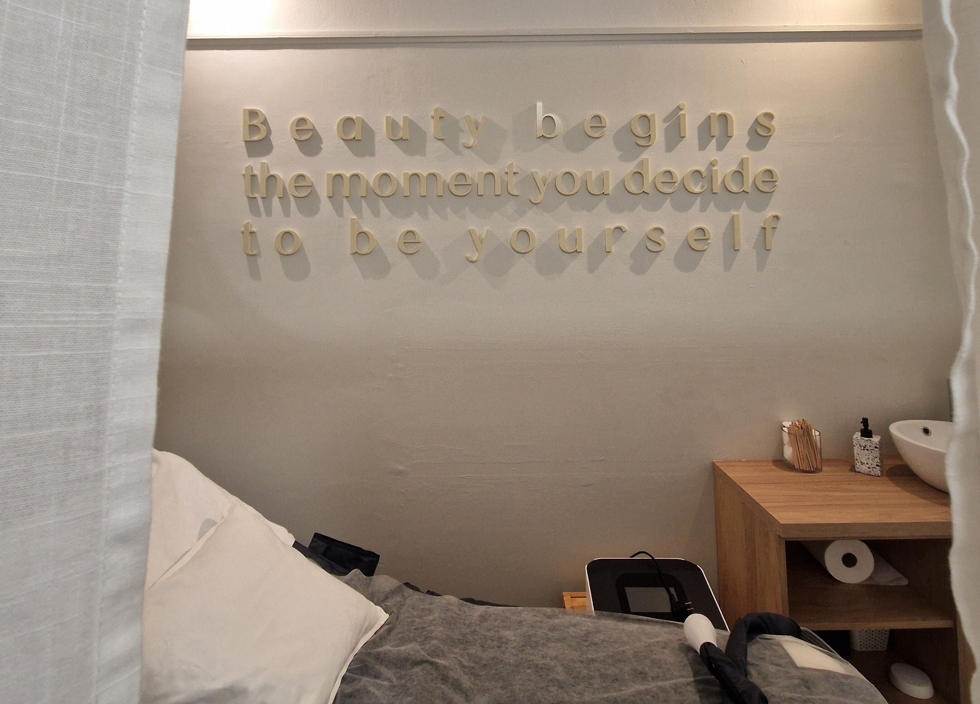 Χώρος θεραπείας στο Avra Ινστιτούτο Αισθητικής, Γαλάτσι, GR, με ειρηνική διακόσμηση και φράση στον τοίχο.