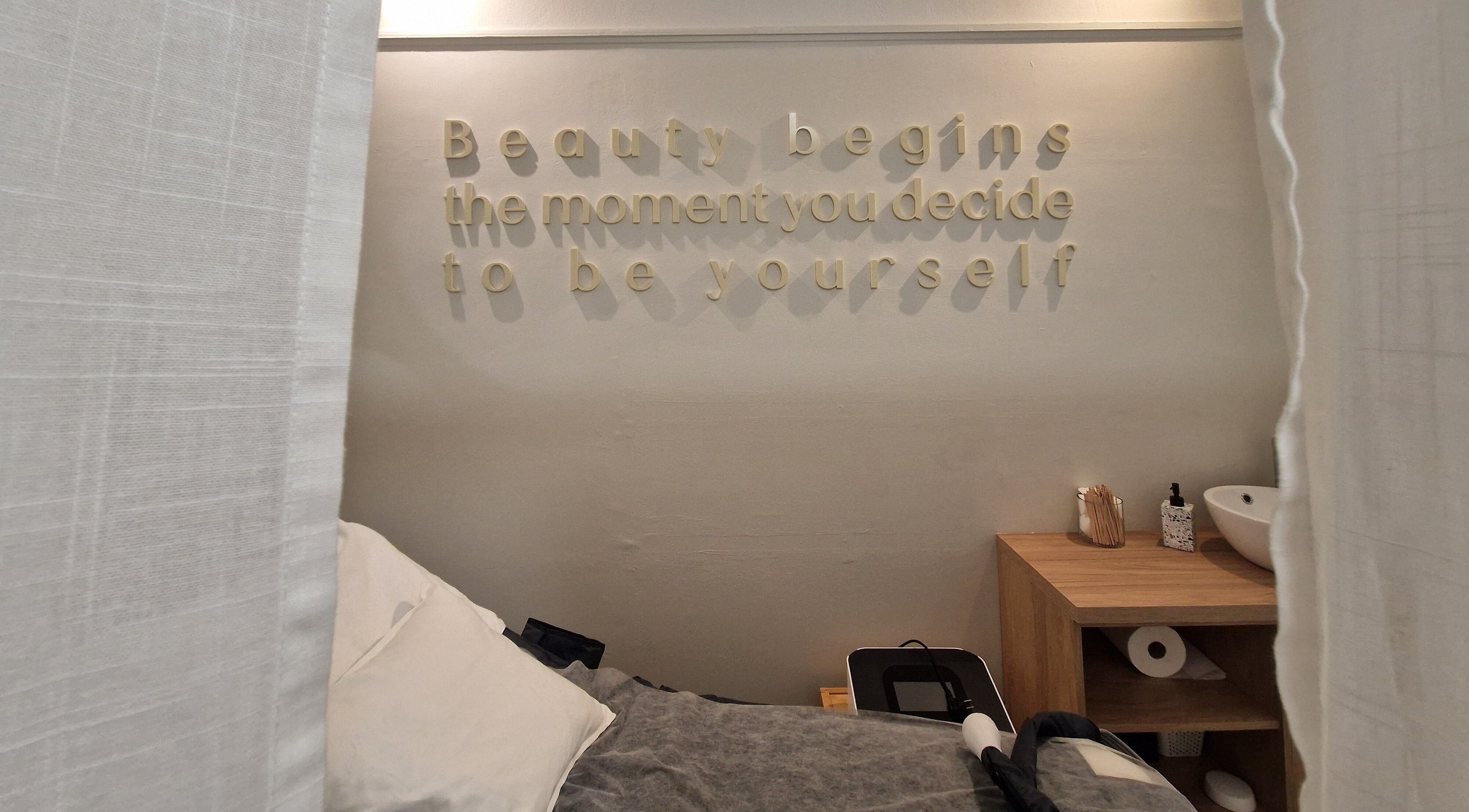 Χώρος θεραπείας στο Avra Ινστιτούτο Αισθητικής, Γαλάτσι, GR, με ειρηνική διακόσμηση και φράση στον τοίχο.