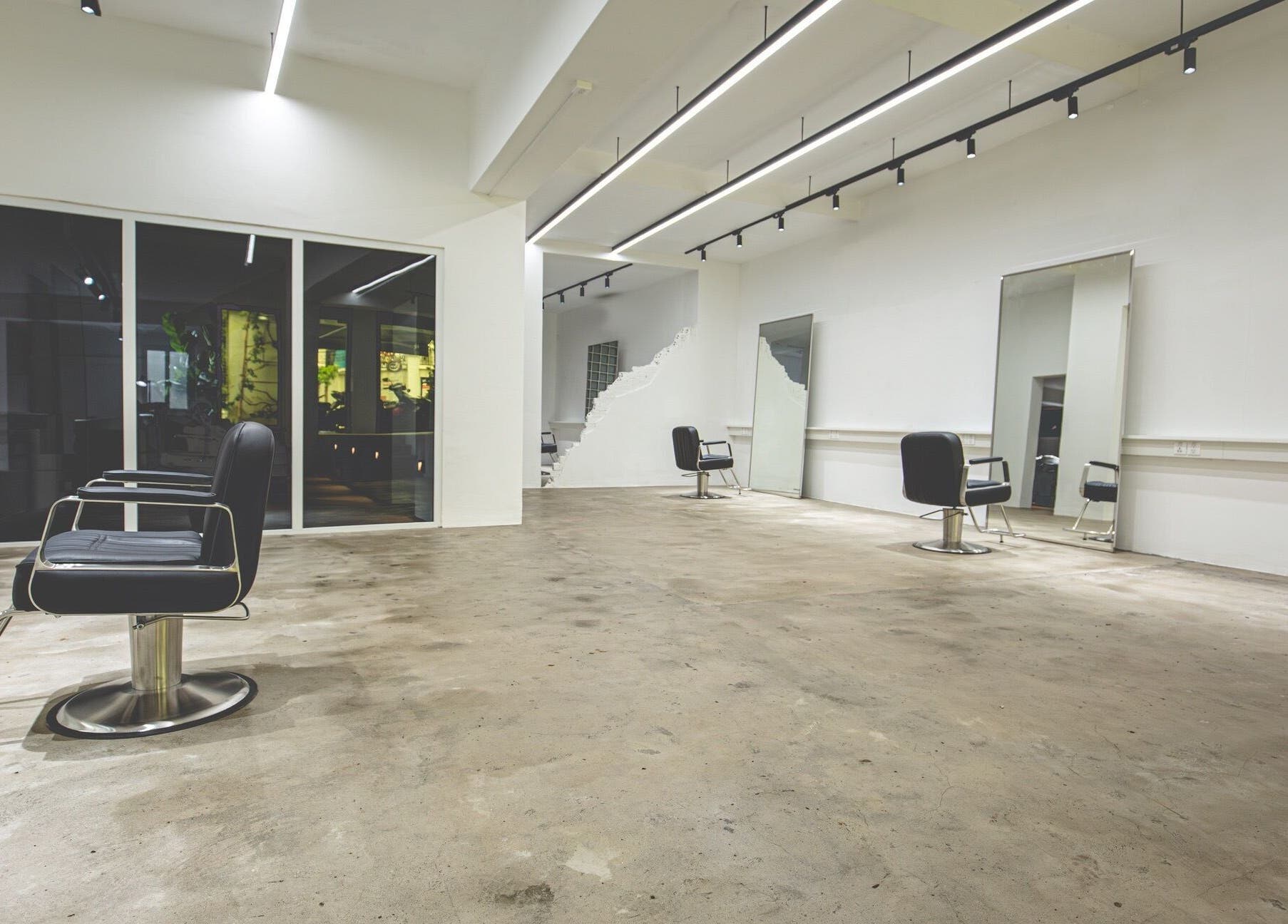 Modern interior of Bangs and Nova salon in Thành Phố Hồ Chí Minh, VN with sleek chairs and large mirrors.