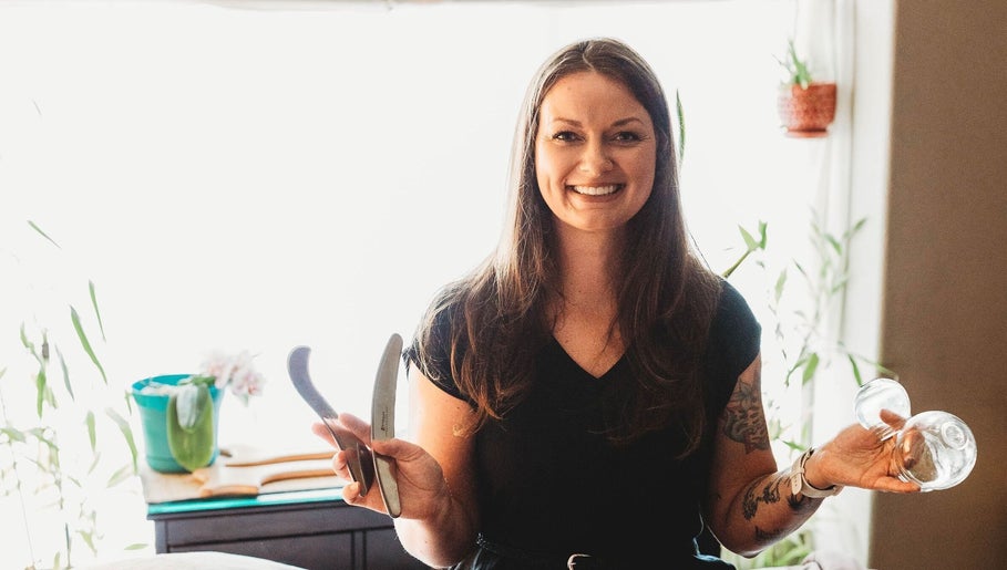 Massage with Liz, LLC therapist holding massage tools in a serene Springfield, Oregon, US setting.