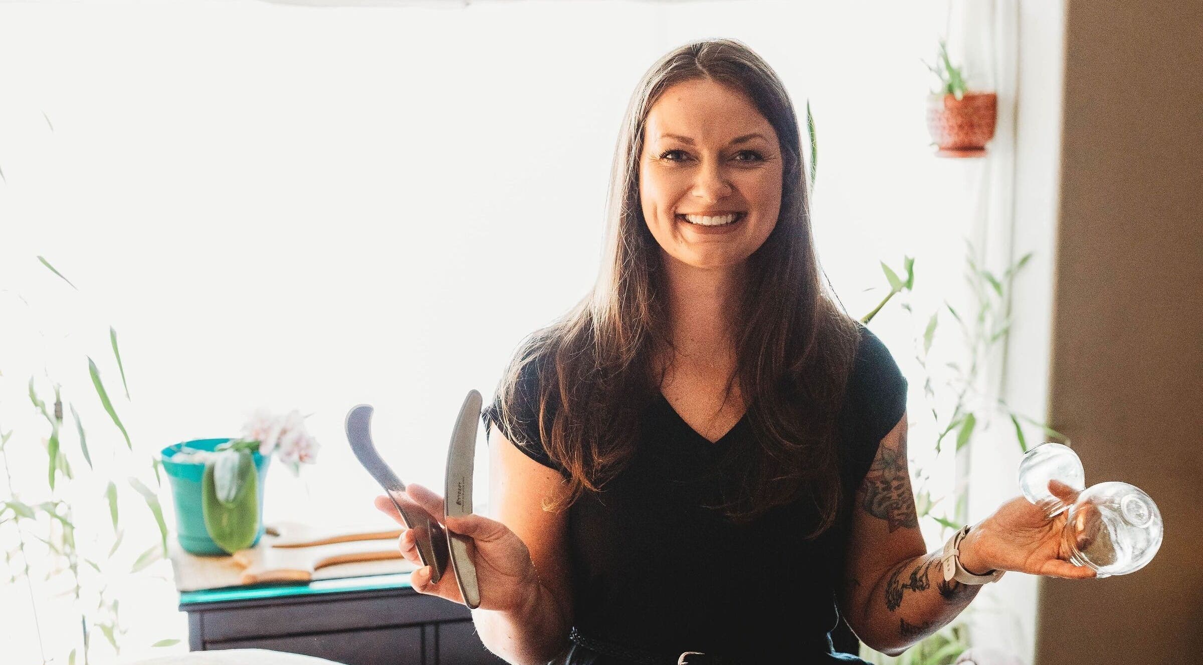 Massage with Liz, LLC therapist holding massage tools in a serene Springfield, Oregon, US setting.