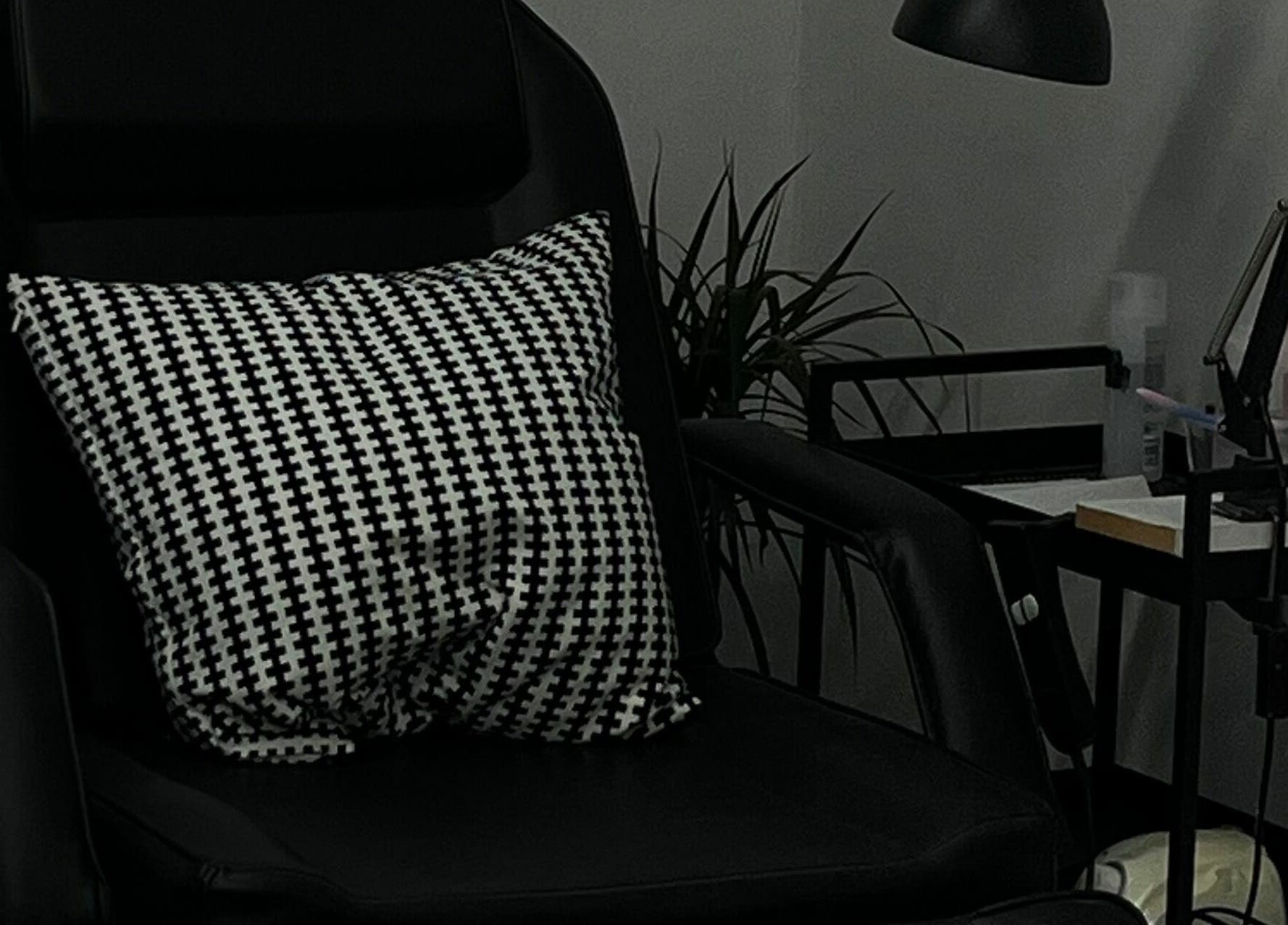 Sleek black chair at Point G beauty salon in London, England, GB with stylish monochrome pillow.