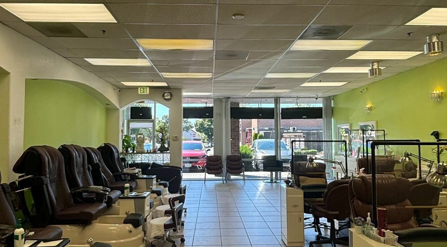 Spacious interior of Great Professional TA Nails in Beaverton, Oregon, US, featuring green walls and comfy chairs.