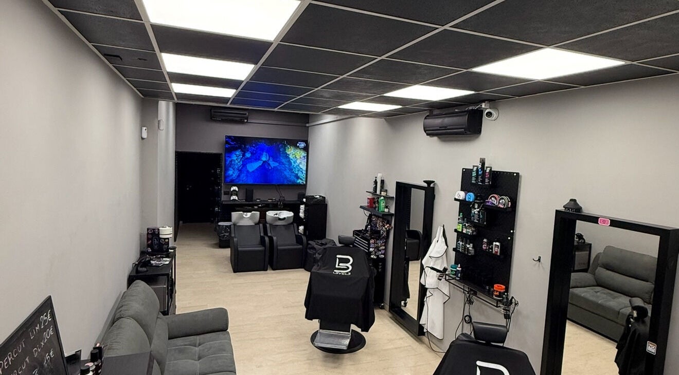 Interno moderno di BARBEROLOGY a San Lazzaro Di Savena, Emilia-romagna, IT con poltrone da barbiere e schermi TV.