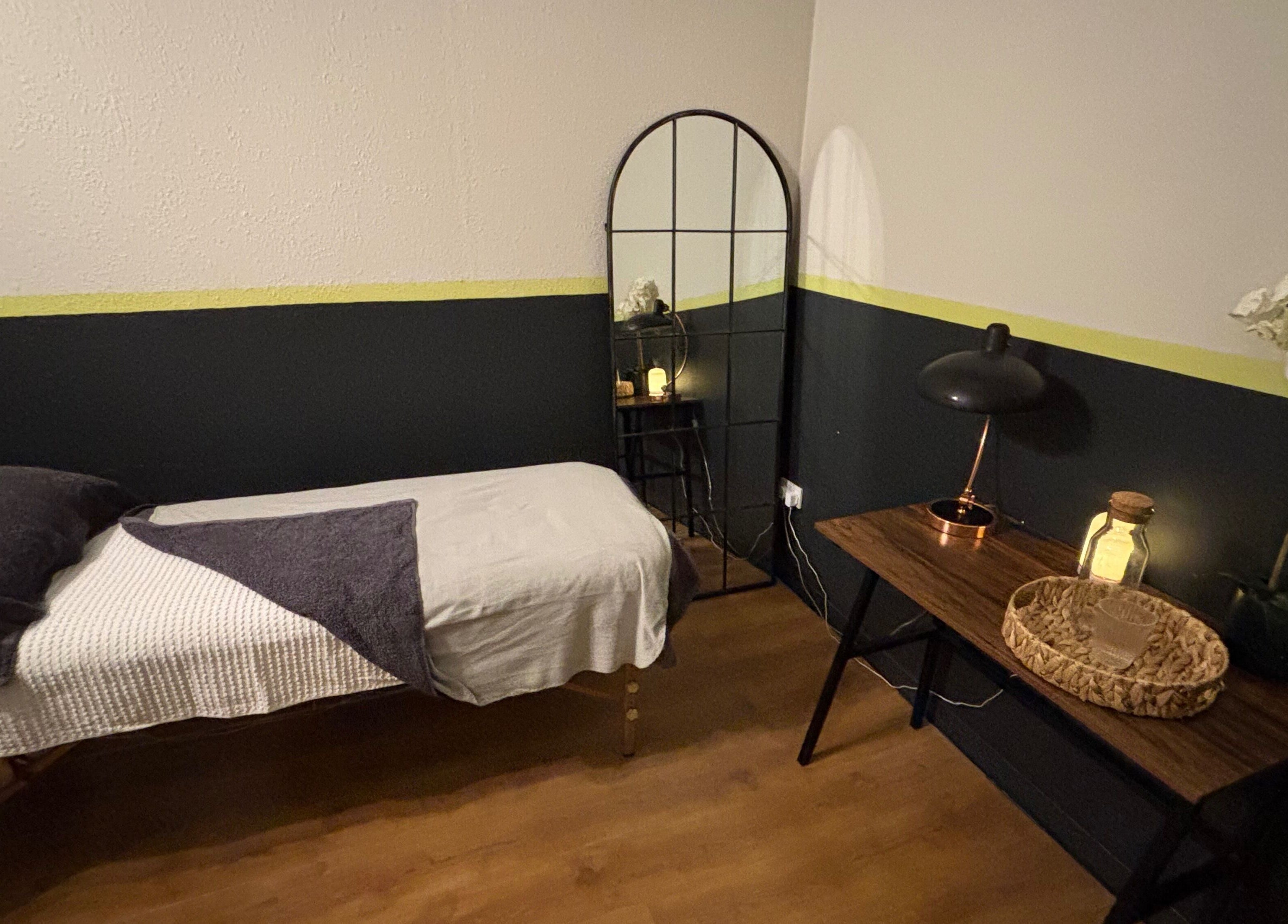 Serene treatment room at Vs Skin, Glasgow, Scotland, GB, featuring a cozy bed and ambient lighting.