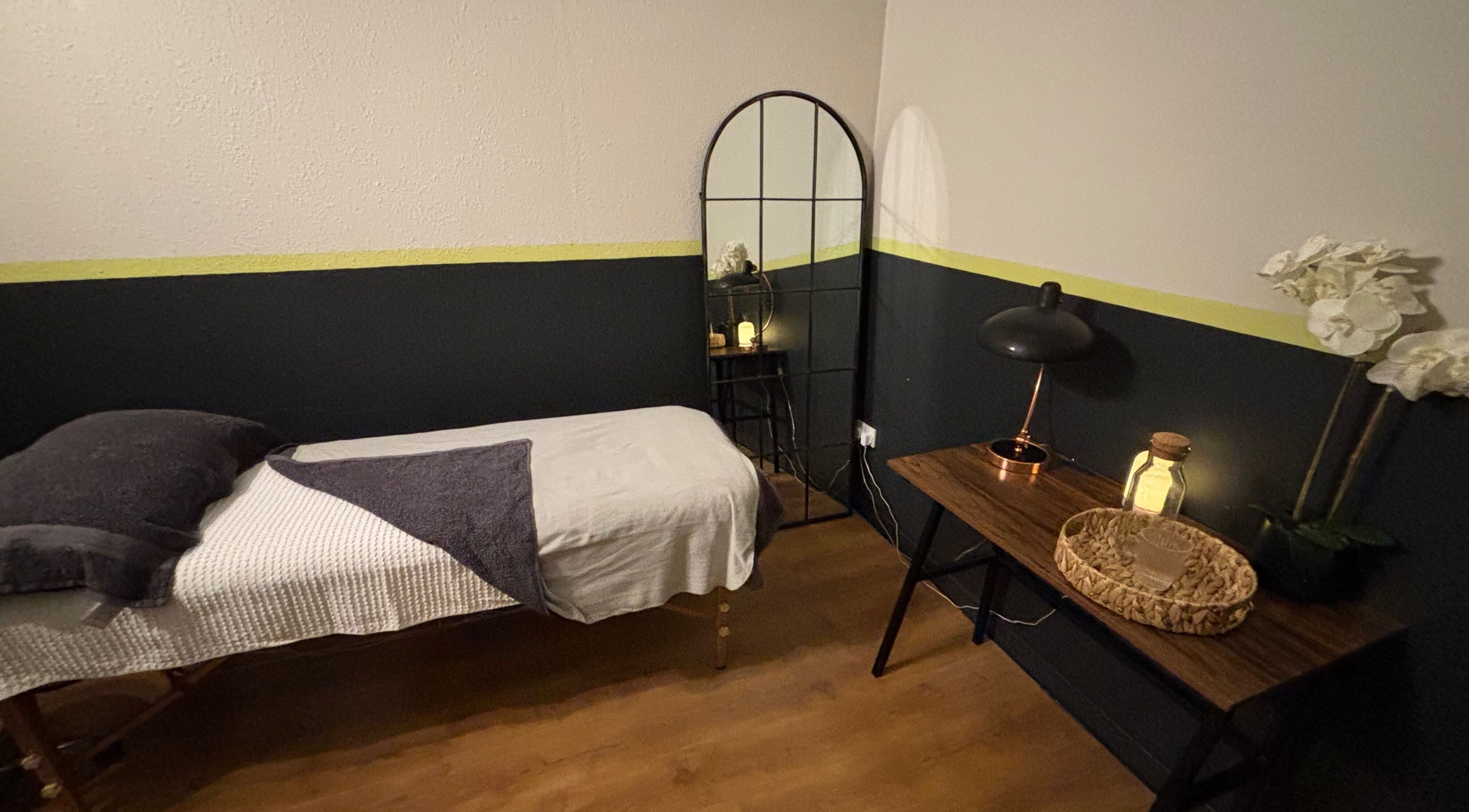 Serene treatment room at Vs Skin, Glasgow, Scotland, GB, featuring a cozy bed and ambient lighting.