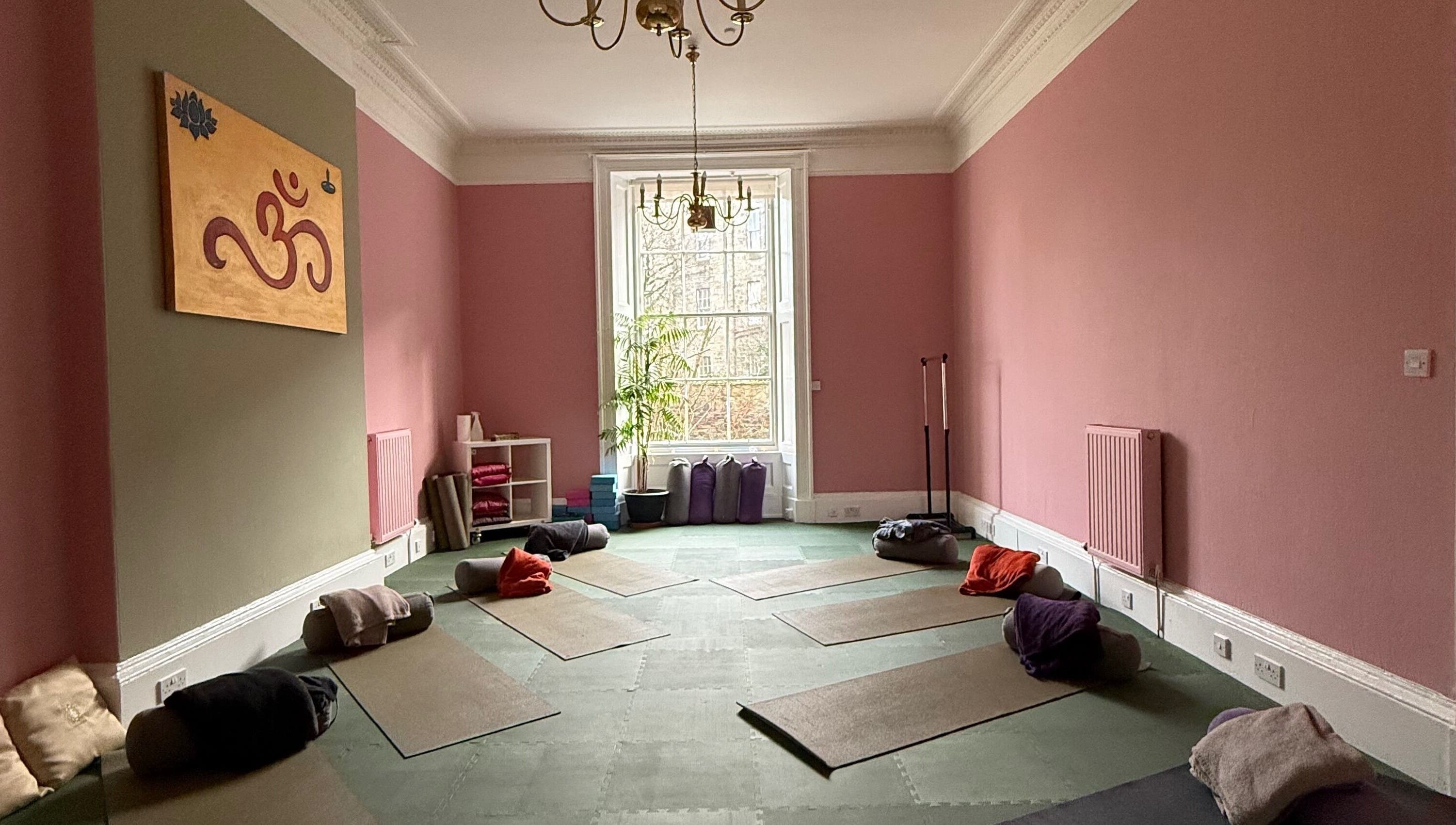 OMH Wellness Studio yoga space with mats and cushions, Edinburgh, Scotland, GB, pink walls and window view.