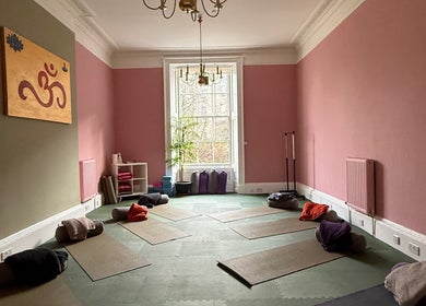 OMH Wellness Studio yoga space with mats and cushions, Edinburgh, Scotland, GB, pink walls and window view.