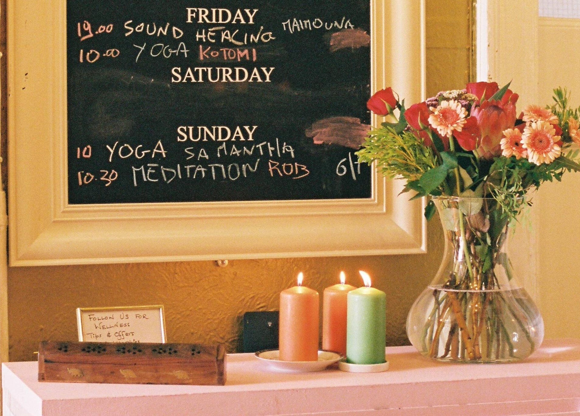 OMH Wellness Studio schedule board with flowers and candles in Edinburgh, Scotland, GB.